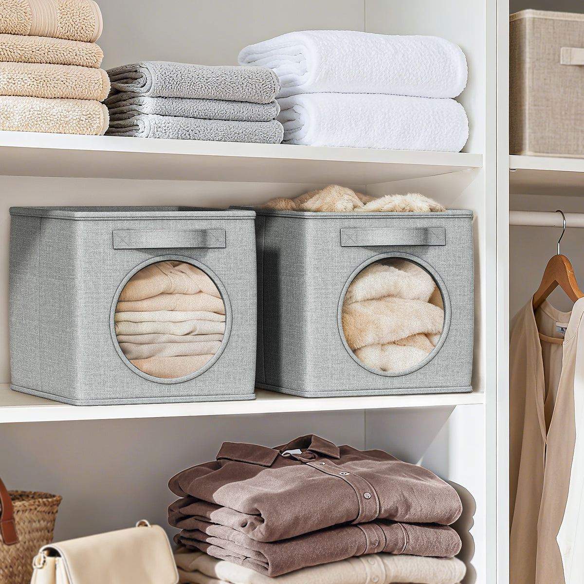 Two linen storage cubes on a shelf holding folded towels and knits