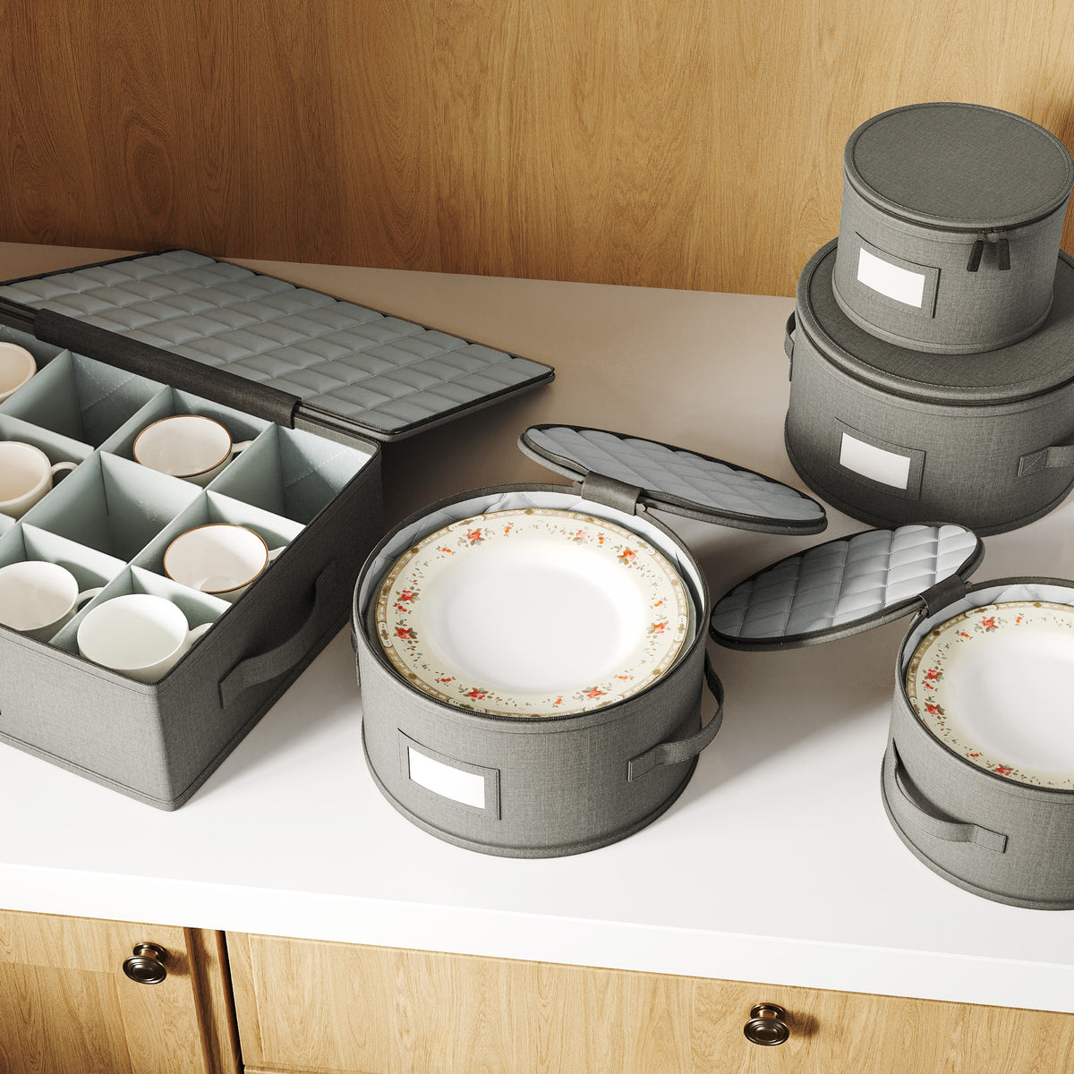 Quilted china storage boxes open on a sideboard with plates and cups inside