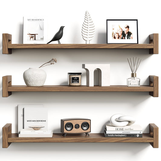 Three solid pine floating shelves in rustic walnut, styled with books and decor